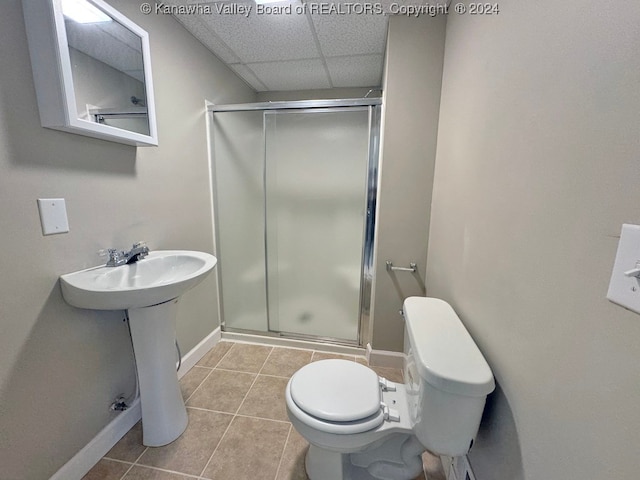 bathroom with toilet, tile patterned floors, a shower with shower door, and a paneled ceiling