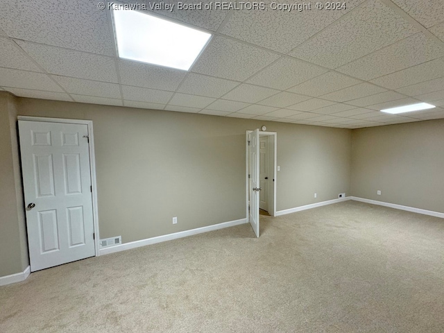 spare room featuring a drop ceiling and carpet