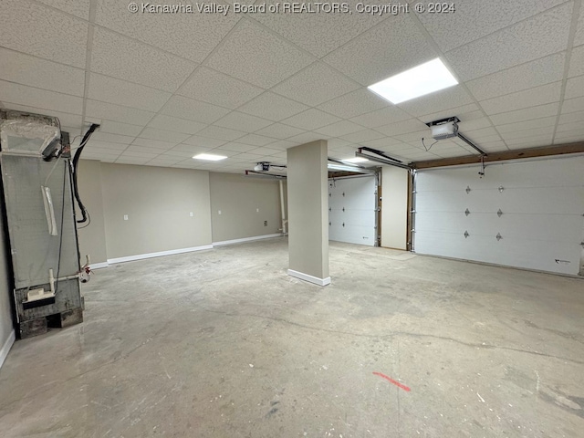 basement with a paneled ceiling and heating unit