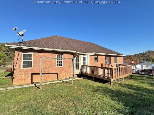 back of property featuring a yard and a wooden deck