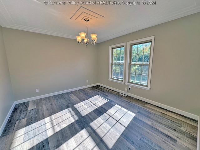 empty room with a chandelier and hardwood / wood-style floors