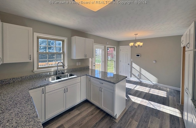 kitchen with white cabinetry, sink, kitchen peninsula, and plenty of natural light