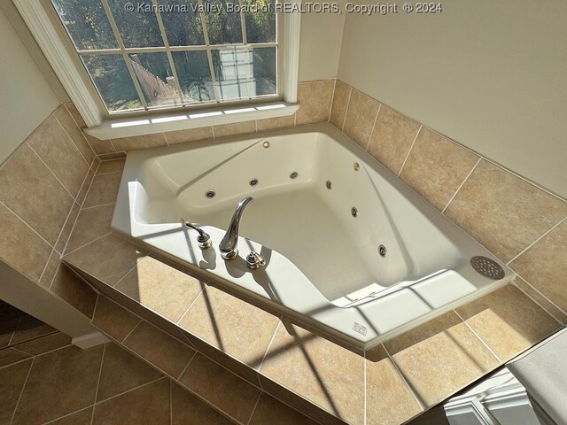 bathroom with tile patterned flooring and tiled bath