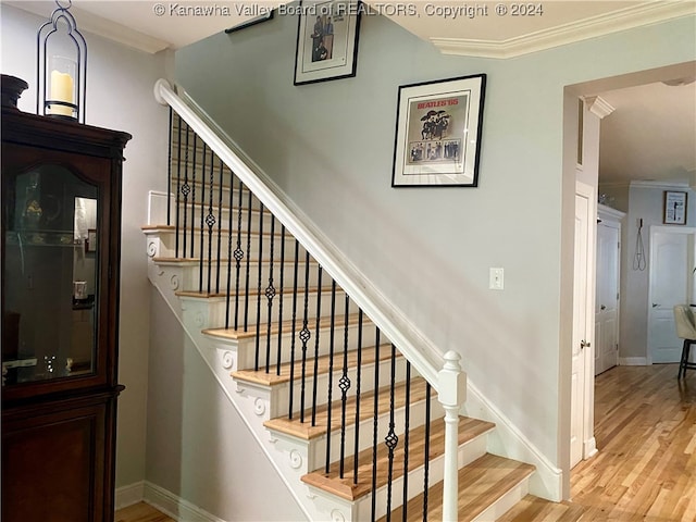 stairs featuring crown molding and hardwood / wood-style floors