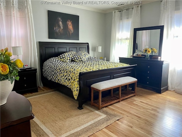 bedroom with crown molding and hardwood / wood-style floors