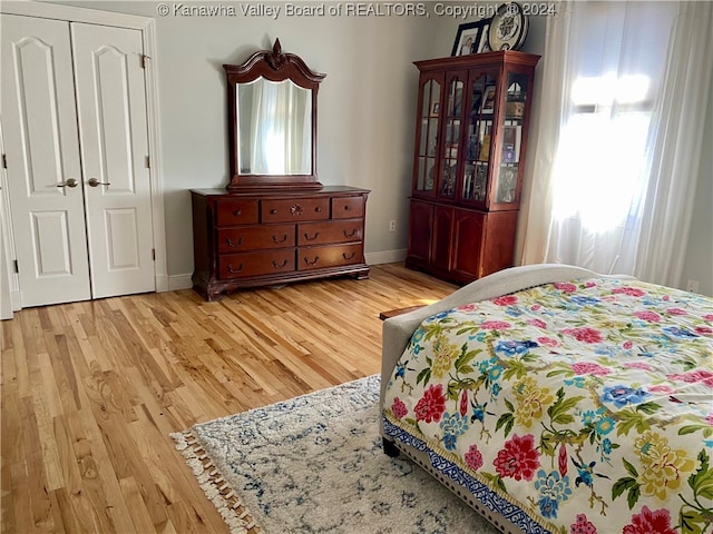 bedroom with light hardwood / wood-style flooring and a closet