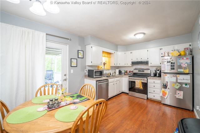 kitchen featuring sink, white cabinets, tasteful backsplash, appliances with stainless steel finishes, and dark hardwood / wood-style flooring