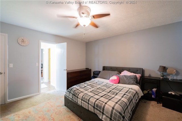 bedroom with ceiling fan, a textured ceiling, and light colored carpet