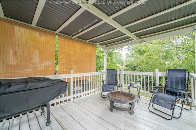 wooden deck with an outdoor fire pit and a grill