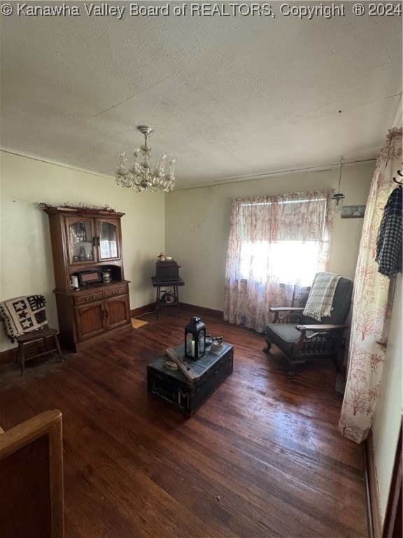 living room with dark hardwood / wood-style floors, a chandelier, and a textured ceiling