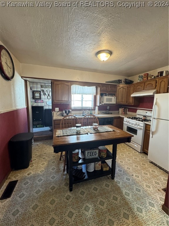 kitchen with a textured ceiling and white appliances