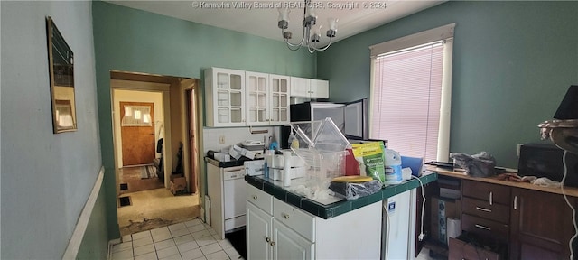 kitchen with tile countertops, a notable chandelier, light colored carpet, and white cabinets