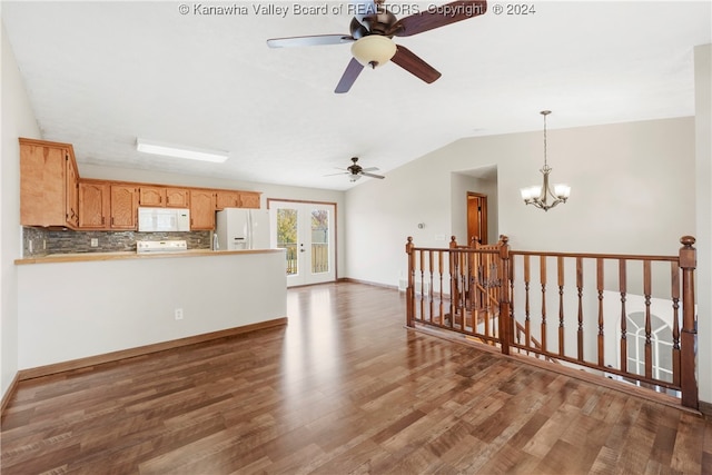 unfurnished living room featuring hardwood / wood-style floors, ceiling fan with notable chandelier, and vaulted ceiling