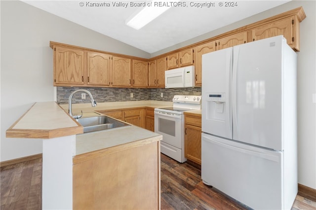 kitchen with kitchen peninsula, sink, vaulted ceiling, white appliances, and dark hardwood / wood-style flooring