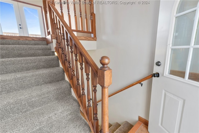 stairs with carpet and french doors