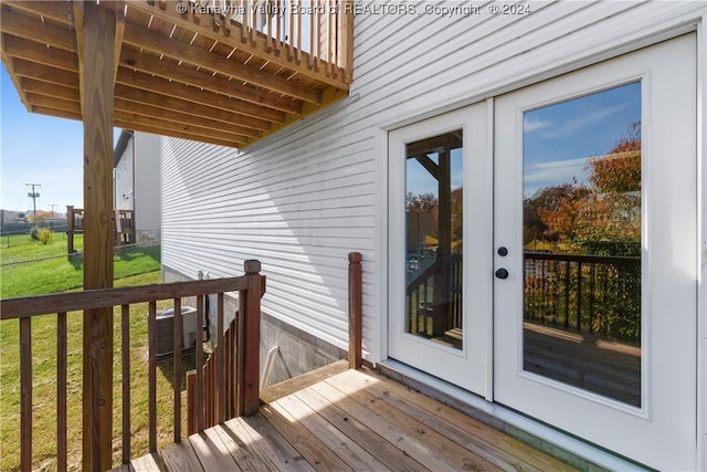 wooden deck with a yard, french doors, and central air condition unit