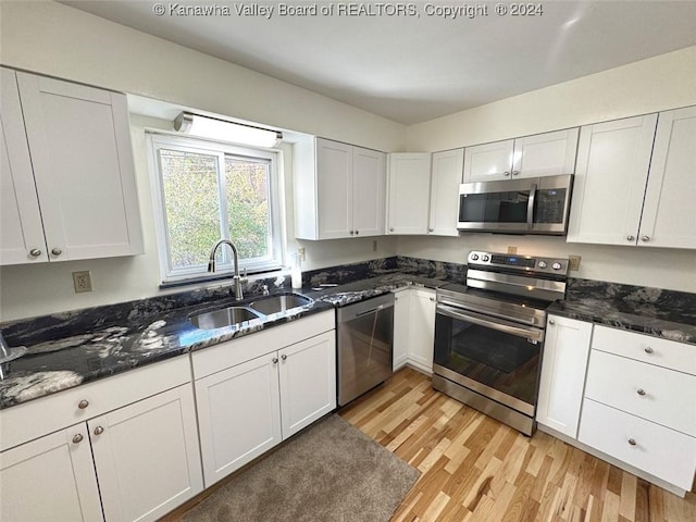 1526 Trace Fork Rd, South Charleston, WV 25309 - kitchen featuring appliances with stainless steel finishes, light wood finished floors, white cabinetry, and dark stone countertops