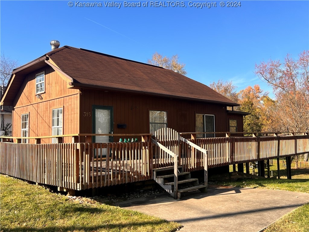 back of house featuring a deck and a yard