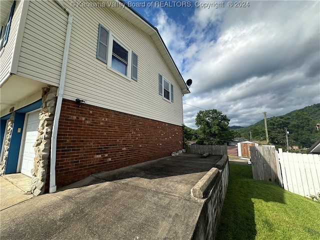 view of home's exterior with a yard, a storage shed, and a garage