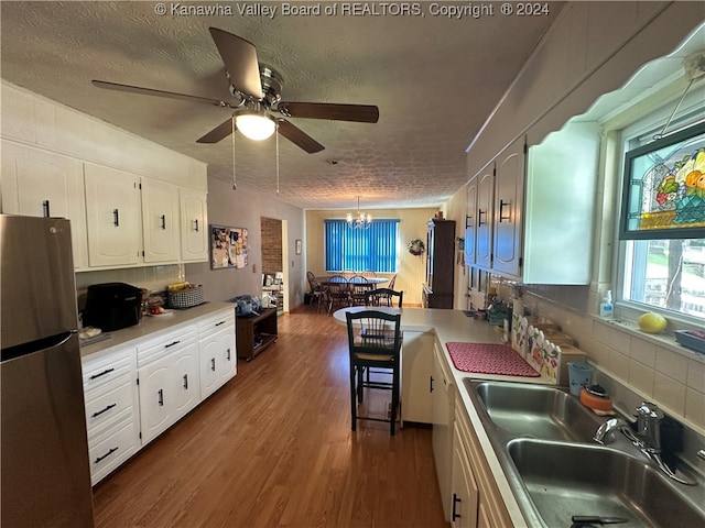 kitchen featuring stainless steel fridge, white cabinets, a textured ceiling, and dark hardwood / wood-style flooring