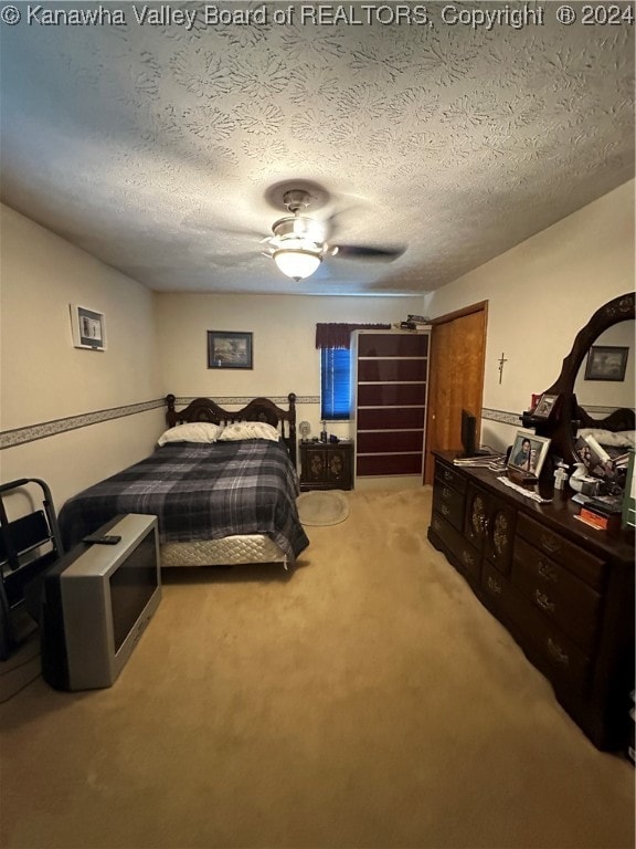 carpeted bedroom with a textured ceiling and ceiling fan