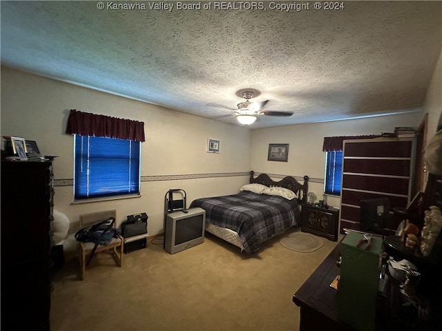 carpeted bedroom with a textured ceiling and ceiling fan