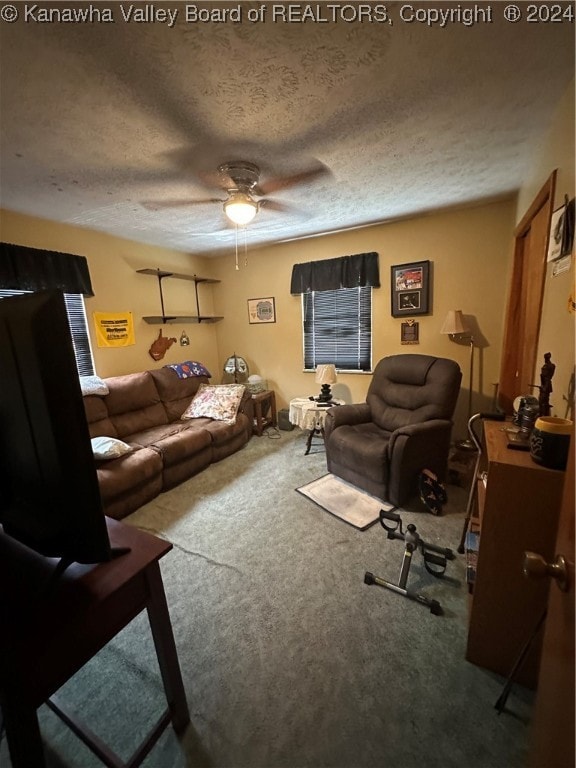 carpeted living room with a textured ceiling and ceiling fan