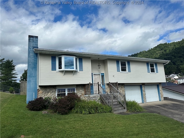 split foyer home featuring a front yard and a garage