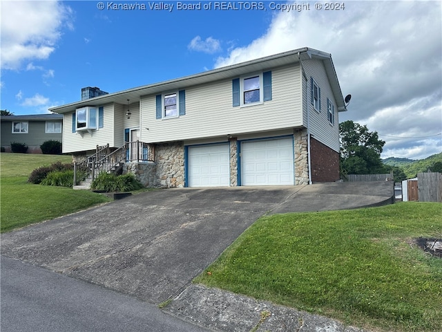 split foyer home with a garage and a front lawn