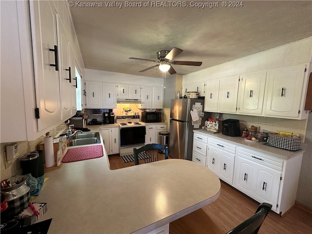 kitchen featuring white electric range oven, stainless steel refrigerator, dark hardwood / wood-style floors, and white cabinets