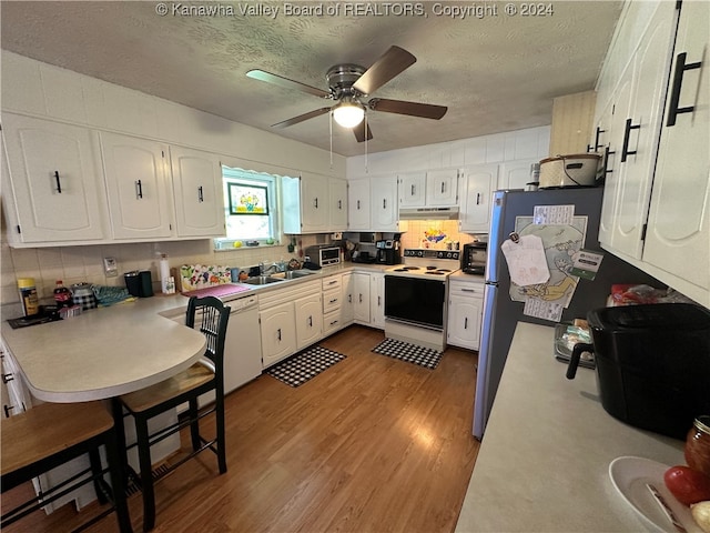 kitchen featuring white cabinets, a textured ceiling, and white appliances