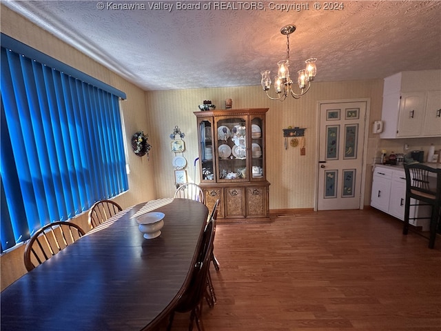 dining space featuring a chandelier, a textured ceiling, and dark hardwood / wood-style flooring