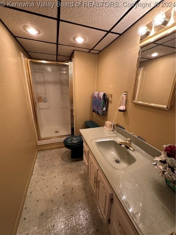 bathroom featuring vanity, a shower with shower door, a paneled ceiling, and toilet