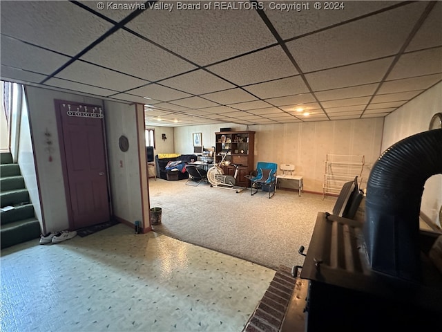 interior space with a paneled ceiling and carpet flooring