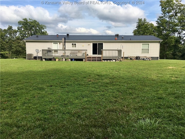 rear view of property featuring central air condition unit, a deck, and a lawn