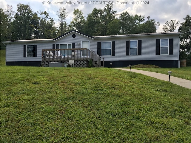 manufactured / mobile home featuring a front lawn and a deck