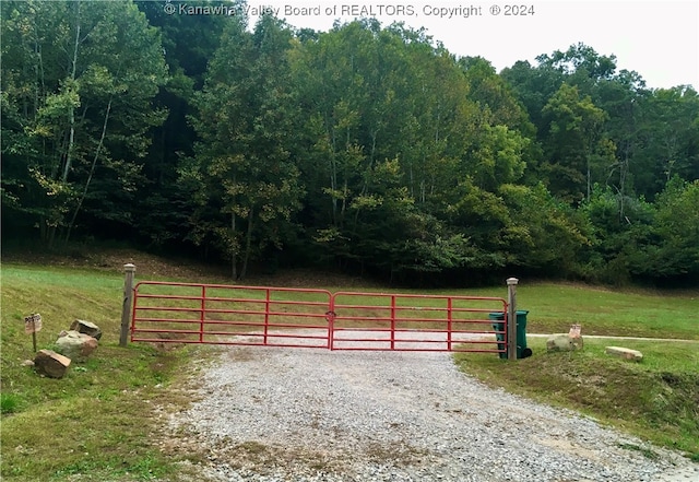 view of gate featuring a yard and a rural view