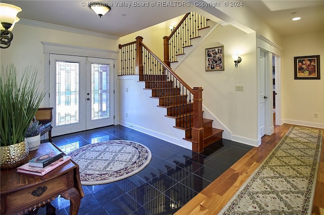 foyer featuring french doors, dark wood-type flooring, and crown molding