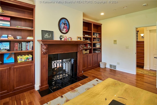 living room with dark wood-type flooring and a multi sided fireplace