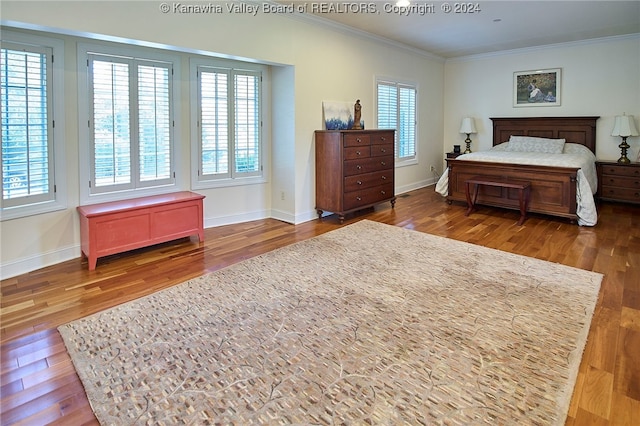 bedroom with ornamental molding and dark hardwood / wood-style floors