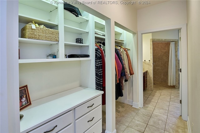 walk in closet with light tile patterned floors