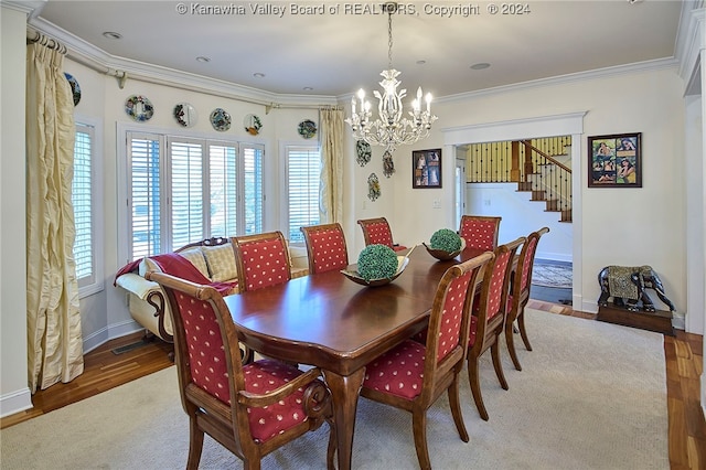 dining area with hardwood / wood-style floors, crown molding, and an inviting chandelier