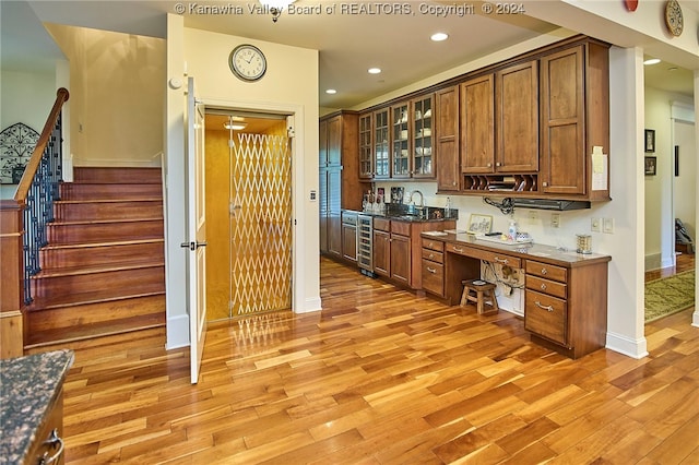 bar featuring light hardwood / wood-style floors, wine cooler, and sink