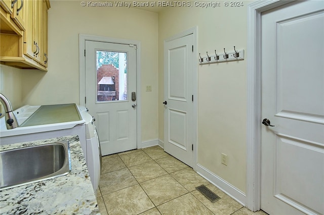 clothes washing area featuring cabinets, independent washer and dryer, sink, and light tile patterned floors