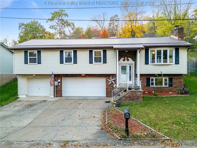 bi-level home featuring a garage and a front lawn