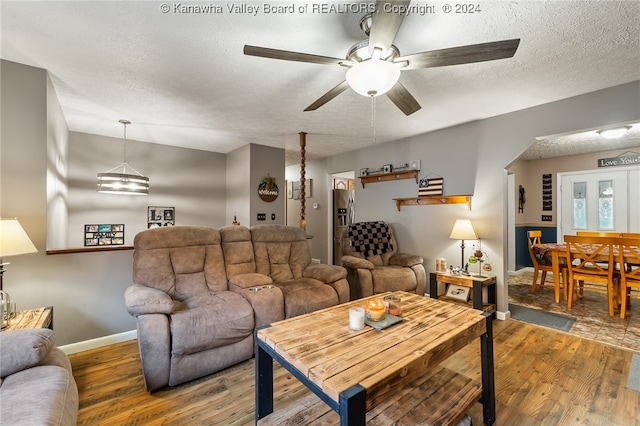 living room featuring a textured ceiling, hardwood / wood-style flooring, and ceiling fan