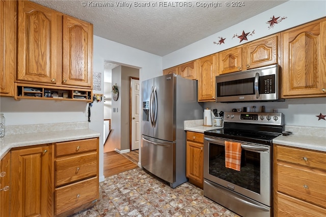 kitchen featuring a textured ceiling and stainless steel appliances