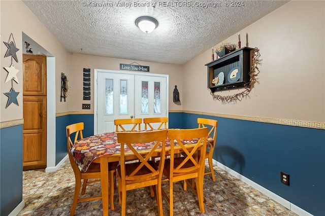 dining room featuring a textured ceiling and french doors