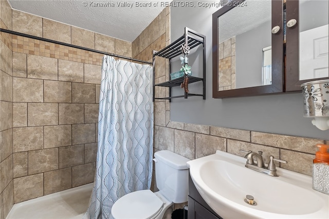 bathroom with toilet, vanity, a textured ceiling, and walk in shower