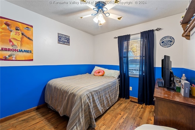 bedroom featuring a textured ceiling, hardwood / wood-style floors, and ceiling fan